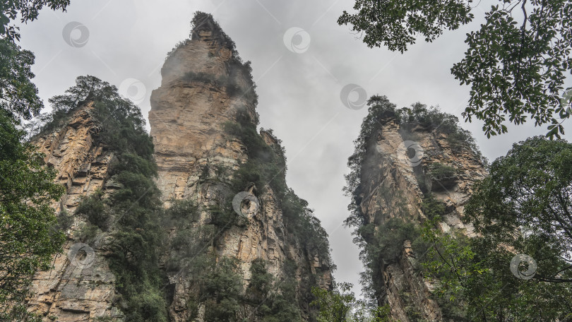 Скачать Причудливые отвесные скалы. Зеленая растительность на крутых склонах. фотосток Ozero