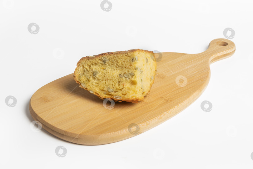 Скачать Ломтик свежего тыквенного хлеба на деревянной доске на белом фоне фотосток Ozero