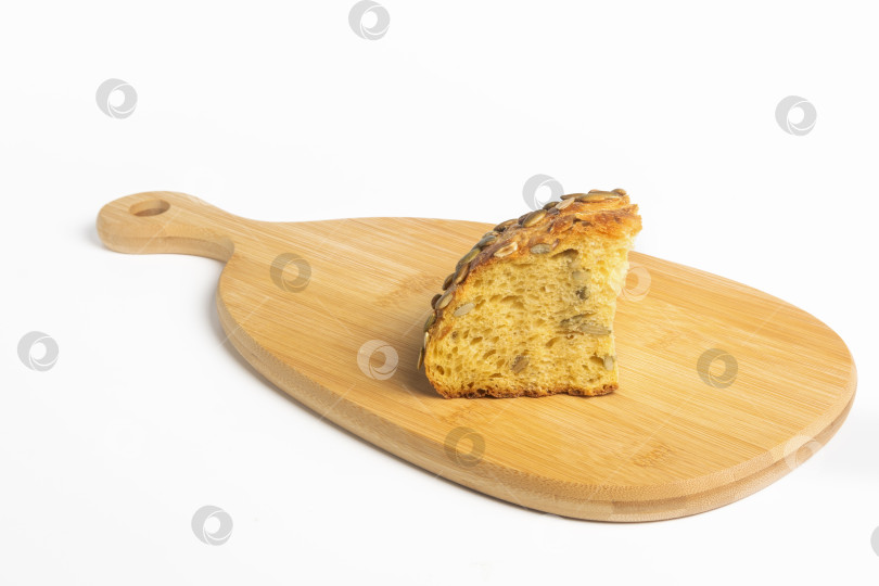 Скачать Ломтик свежего тыквенного хлеба на деревянной доске на белом фоне фотосток Ozero