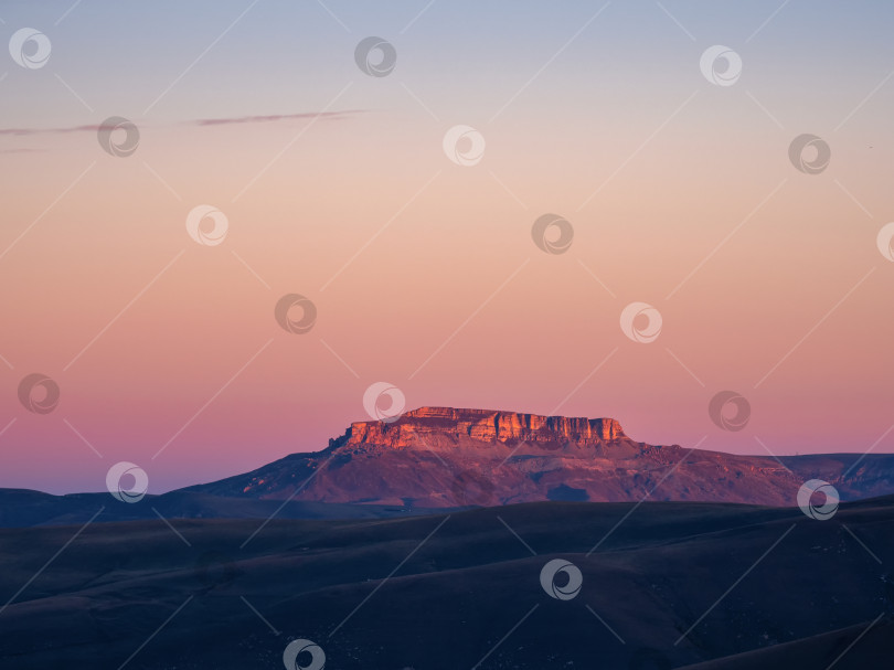 Скачать Волшебный пурпурный рассвет над плато Бермамыт. Вдалеке виден атмосферный рассветный пейзаж с прекрасным плато Бермамыт. фотосток Ozero