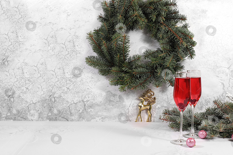 Скачать Рождественский алкогольный коктейль с красным шампанским "Мимоза" и клюквой в бокалах на праздничном фоне с еловыми ветками и украшениями, концепция бара и сочельника, алкогольные напитки на вечеринке фотосток Ozero