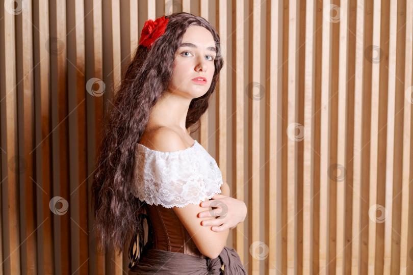 Скачать Женщина с длинными каштановыми волосами и красным цветком в волосах фотосток Ozero