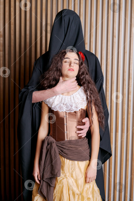 Скачать Мужчина обнимает женщину за шею, и она одета в костюм фотосток Ozero