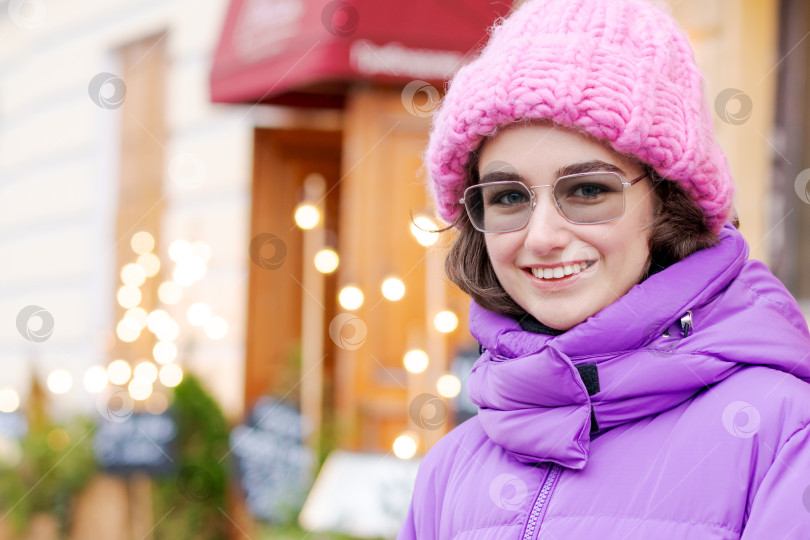 Скачать Женщина в розовой шляпке и фиолетовом пальто улыбается фотосток Ozero