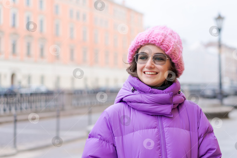 Скачать Женщина в розовой шляпке и фиолетовом пальто улыбается фотосток Ozero