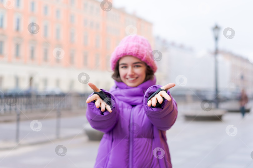 Скачать Женщина в фиолетовом пальто и розовой шляпке улыбается и поднимает вверх большой палец фотосток Ozero