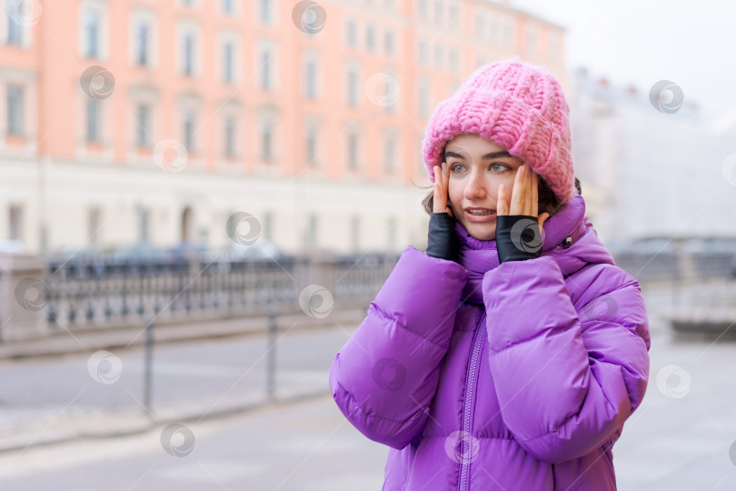 Скачать На тротуаре стоит женщина в розовой шляпке и фиолетовом пальто фотосток Ozero