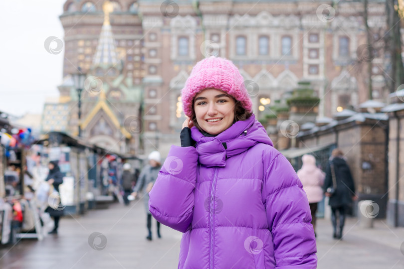 Скачать Женщина в фиолетовом пальто и розовой шляпе разговаривает по мобильному телефону фотосток Ozero
