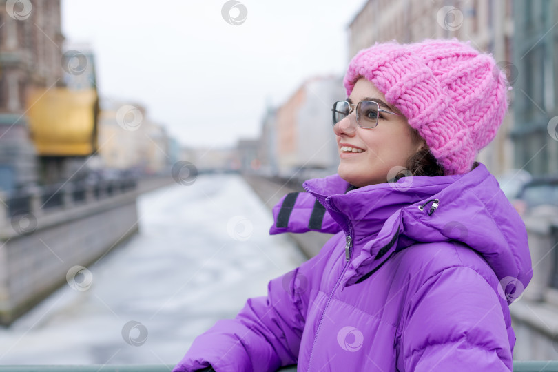 Скачать Женщина в розовой шляпке и фиолетовом пальто улыбается фотосток Ozero