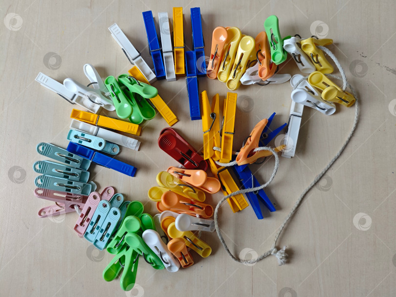 Скачать Цветные прищепки для белья на веревке. Цветные прищепки для одежды на веревке. фотосток Ozero