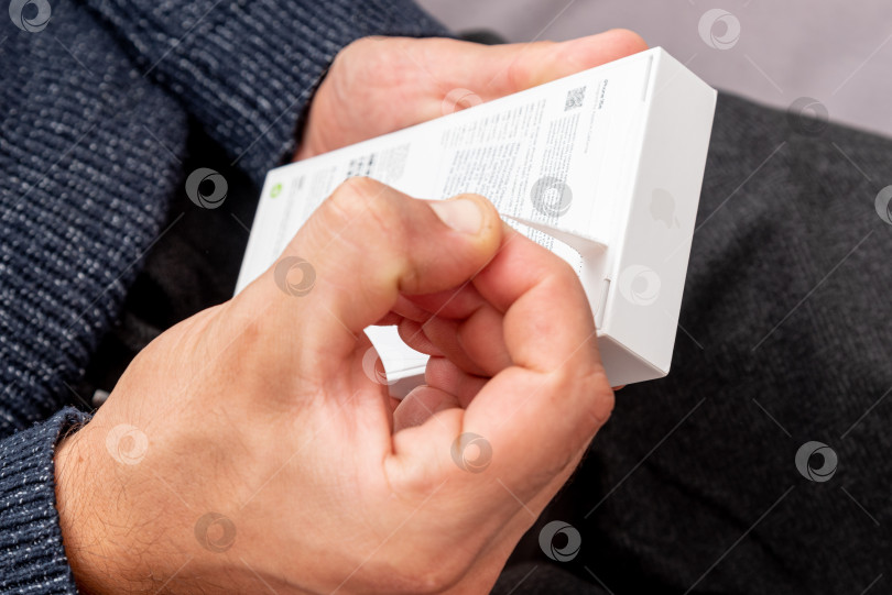 Скачать Бар, Черногория, 2 ноября 2025 года, Мужчина распаковывает новый смартфон iphone в открытой коробке фотосток Ozero