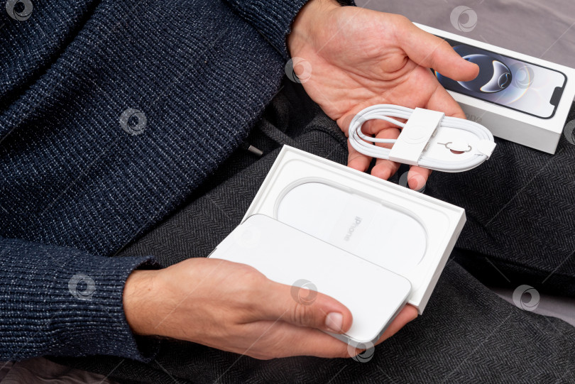 Скачать Бар, Черногория, 2 ноября 2025 года, Мужчина распаковывает новый смартфон iphone в открытой коробке фотосток Ozero