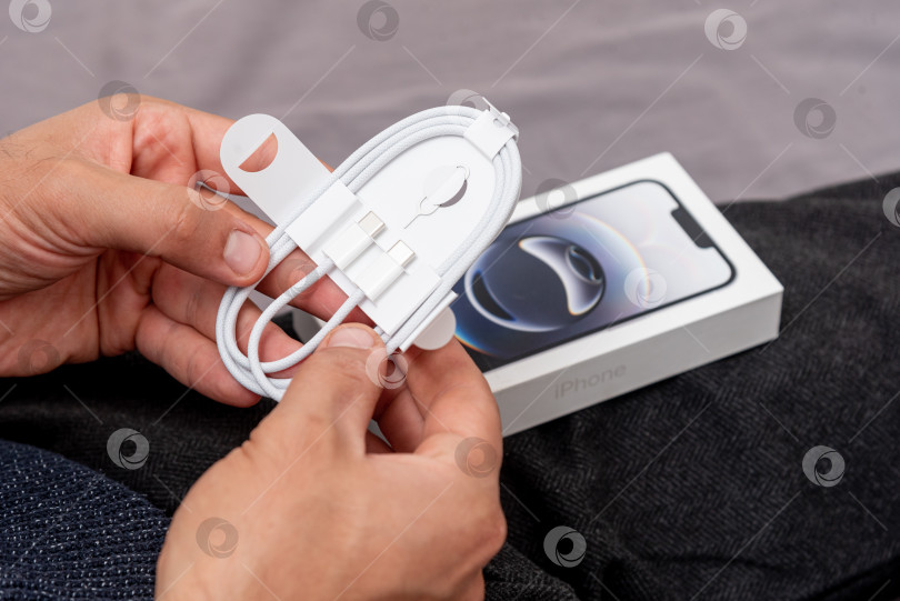 Скачать Бар, Черногория, 2 ноября 2025 года, Мужчина распаковывает новый смартфон iphone в открытой коробке фотосток Ozero