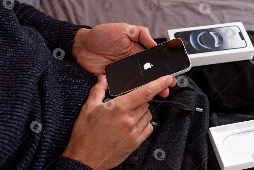 Скачать Бар, Черногория, 2 ноября 2025 года, Мужчина настраивает новый iPhone, первый запускаемый смартфон фотосток Ozero