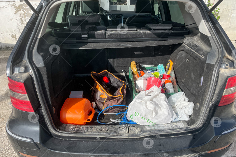 Скачать Беспорядок в багажнике автомобиля, представление о необходимости сортировки оборудования для удобства фотосток Ozero