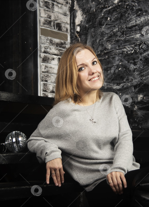 Скачать Молодая девушка в серой кофте у зеркала фотосток Ozero