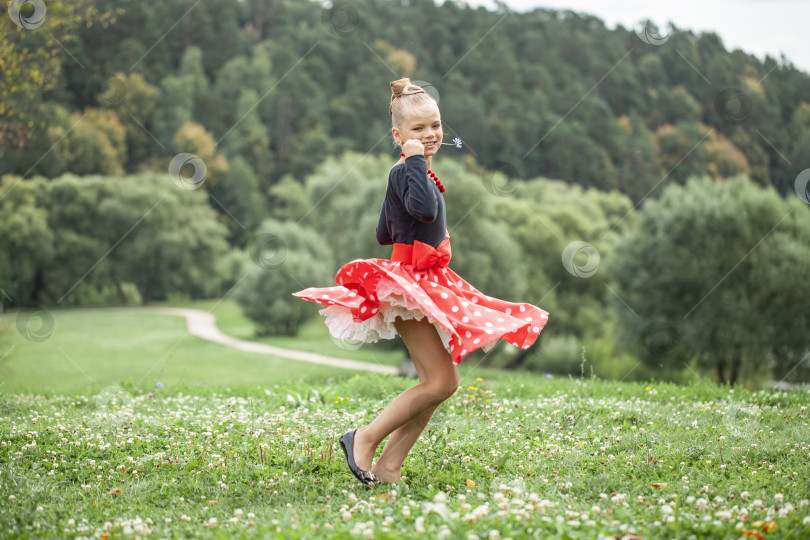Скачать Маленькая девочка танцует ретро-танец в стиле пин-ап в летнем парке фотосток Ozero