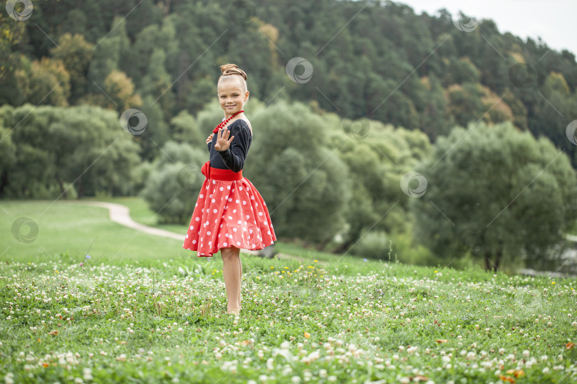 Скачать Маленькая девочка танцует ретро-танец в стиле пин-ап в летнем парке фотосток Ozero