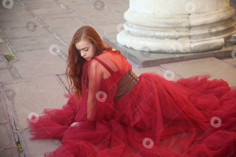 Скачать Молодая девушка в красном платье позирует на улице фотосток Ozero