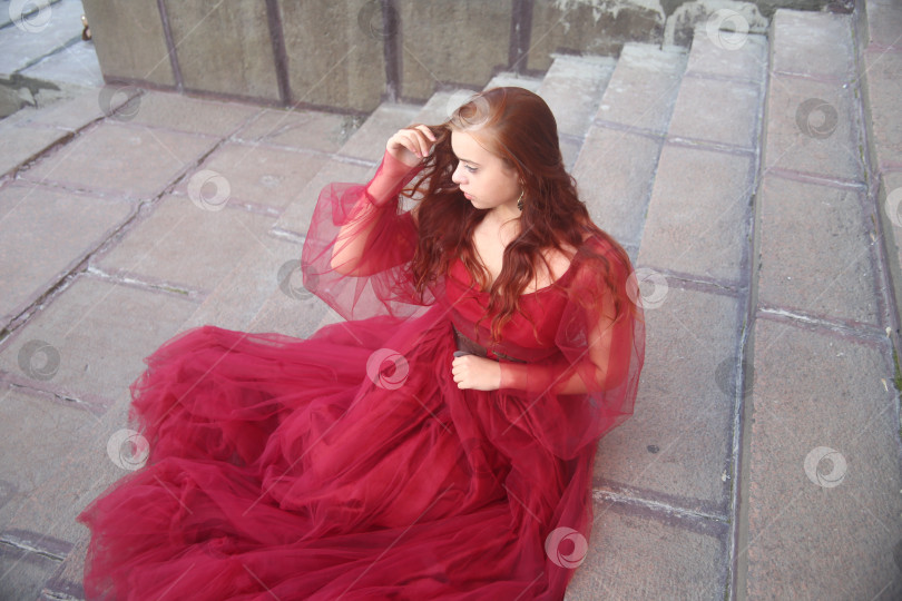 Скачать Красивая и молодая девушка в красном пышном платье фотосток Ozero