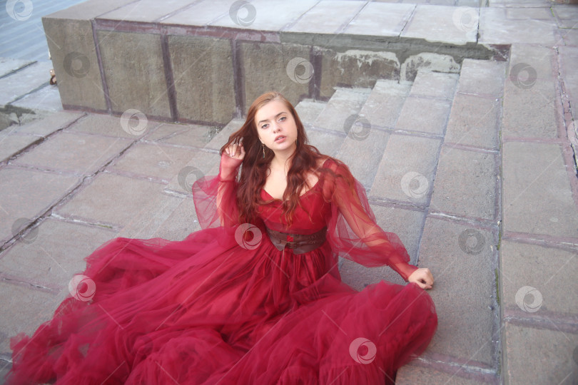 Скачать Молодая девушка в красном платье на лестнице фотосток Ozero