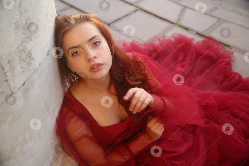 Скачать Молодая девушка в красном платье позирует фотосток Ozero