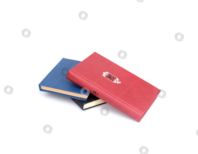 Скачать Стопки красных, черных и синих книг, выделяющихся на белом фоне фотосток Ozero