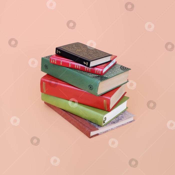 Скачать Стопка книг в цветных обложках с белыми листами, выделяющимися на розовом фоне фотосток Ozero
