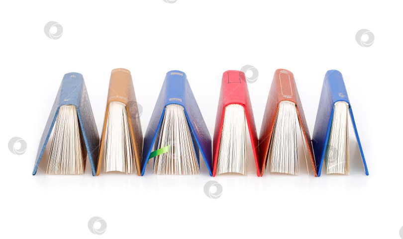 Скачать Стопка книг в цветных обложках с белыми листами, выделяющимися на белом фоне фотосток Ozero