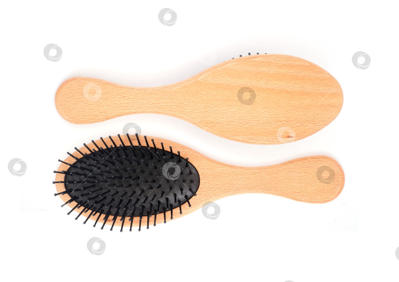 Скачать Овальные щетки для волос с деревянной ручкой и черными щетинками, выделяющимися на белом фоне, готовы к использованию. Чрезвычайно высокое разрешение фотосток Ozero