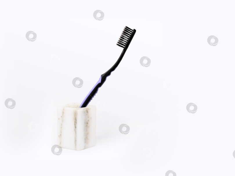 Скачать Черная зубная щетка в мраморной вазе на белом фоне фотосток Ozero