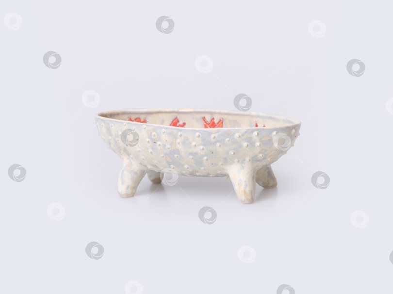 Скачать Керамическая ваза ручной работы с цветочным орнаментом на ножках, выделяющаяся на белом фоне фотосток Ozero