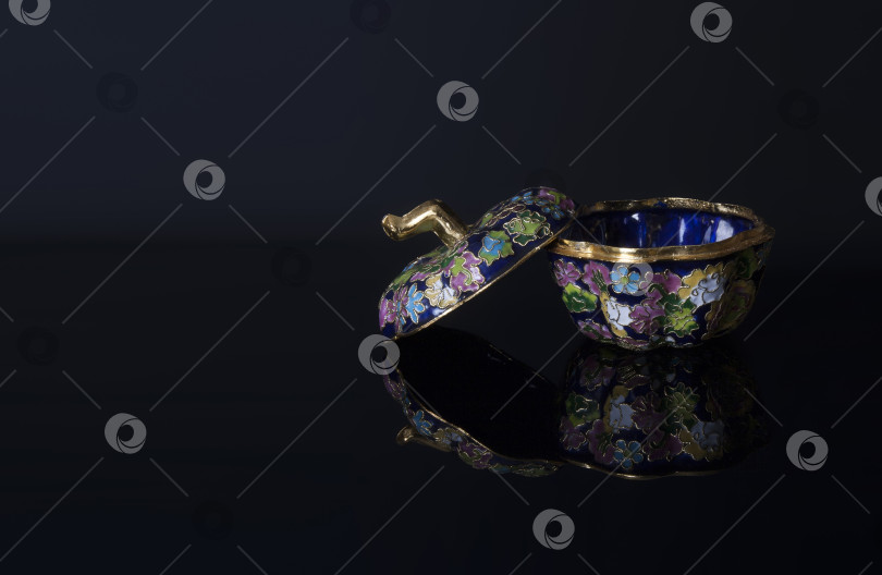 Скачать Традиционная китайская металлическая шкатулка, украшенная разноцветной эмалью, выделяющейся на черном фоне фотосток Ozero