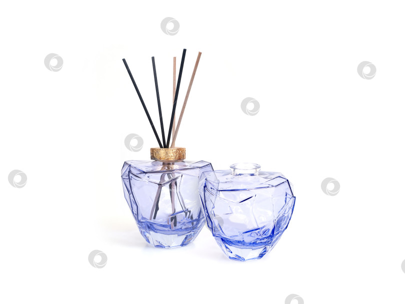 Скачать Два стеклянных тростниковых диффузора для эфирных масел с деревянными палочками, выделяющимися на белом фоне, готовый вырез фотосток Ozero