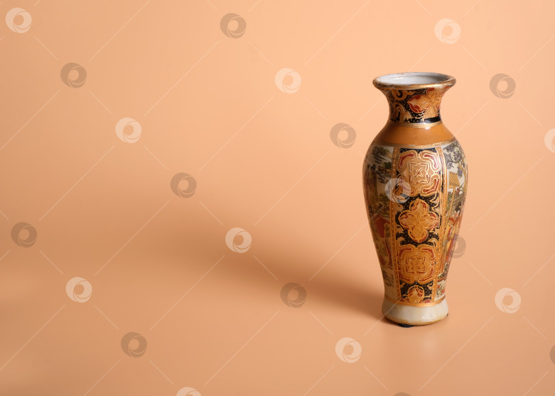 Скачать Китайская ваза в старинных традициях, выделенная на оранжевом фоне фотосток Ozero