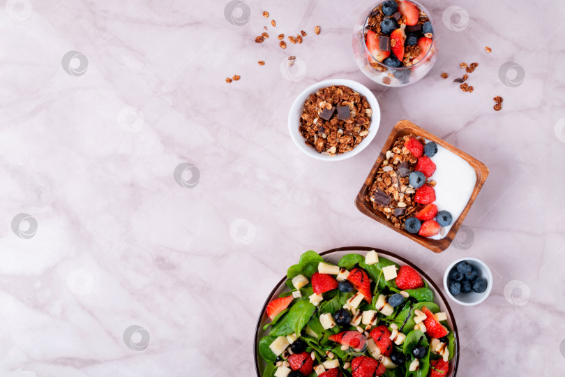 Скачать Йогурт с шоколадной гранолой и ягодами. Салат с клубникой, шпинатом, черникой, сыром качотта и кедровыми орешками фотосток Ozero