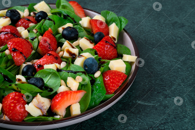Скачать Салат с клубникой, шпинатом, черникой, сыром качотта и кедровыми орешками, заправленный бальзамической глазурью фотосток Ozero