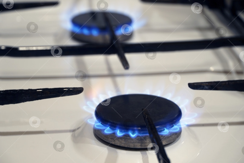 Скачать Газовые конфорки кухонной плиты с голубым пламенем. Горящие газовые горелки. фотосток Ozero
