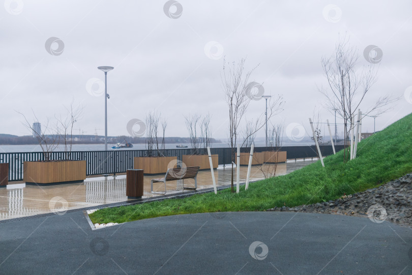 Скачать Пустые скамейки на набережной озера в пасмурную погоду фотосток Ozero