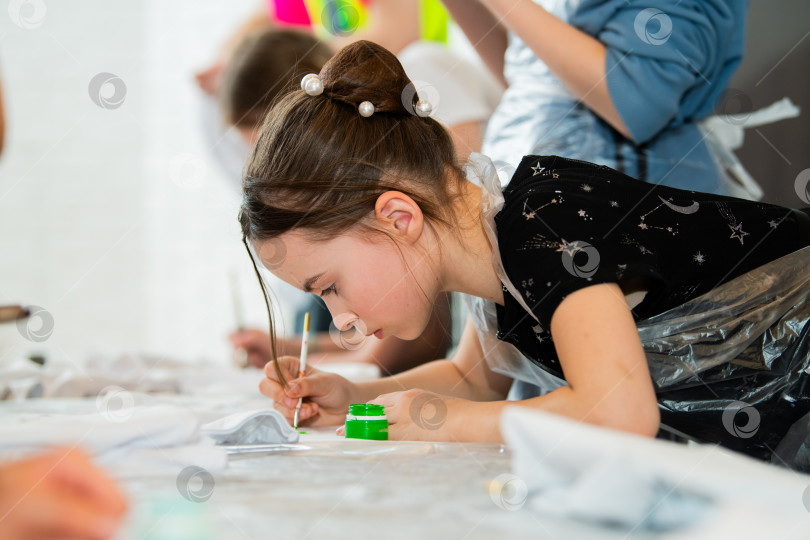 Скачать Молодая девушка сосредоточилась на рисовании на уроке изобразительного искусства фотосток Ozero