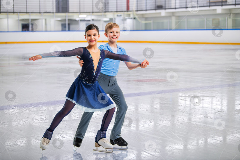 Скачать Юные фигуристы в элегантных танцах на льду - спортивные пары на соревнованиях фотосток Ozero