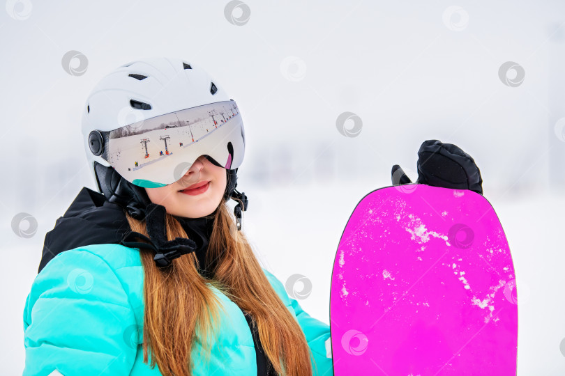 Скачать Портрет молодой девушки со сноубордом в лыжных очках, отражающий горнолыжный подъемник. фотосток Ozero