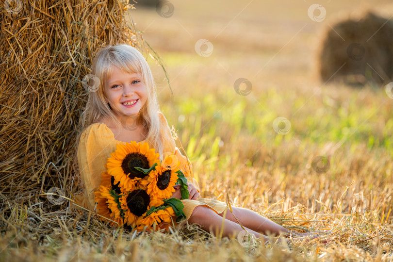 Скачать Улыбающаяся девушка с подсолнухами в поле фотосток Ozero