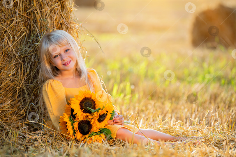 Скачать Улыбающаяся девушка с подсолнухами в поле фотосток Ozero