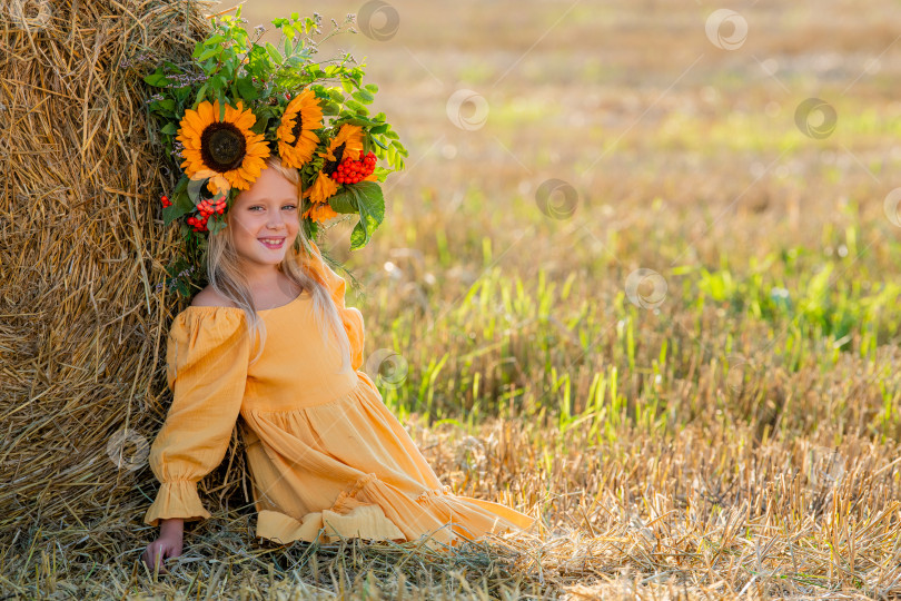 Скачать Улыбающийся ребенок с короной из подсолнухов на солнечном поле фотосток Ozero