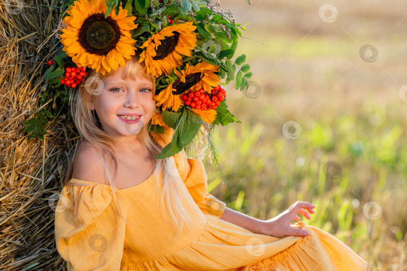 Скачать Улыбающийся ребенок с короной из подсолнухов на солнечном поле фотосток Ozero