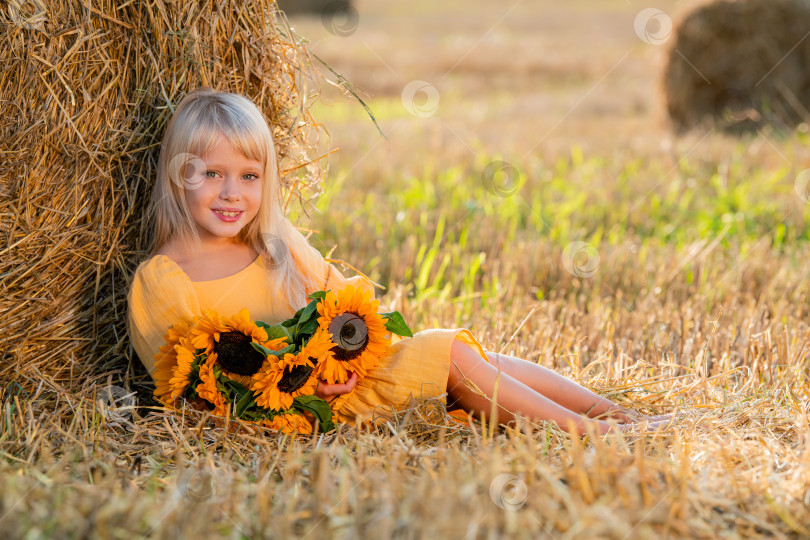 Скачать Улыбающаяся девушка с подсолнухами в поле фотосток Ozero