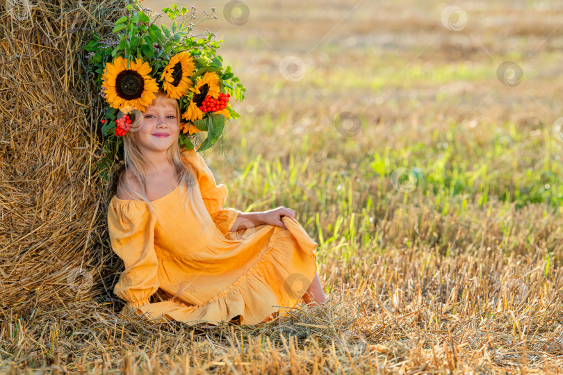 Скачать Улыбающийся ребенок с короной из подсолнухов на солнечном поле фотосток Ozero