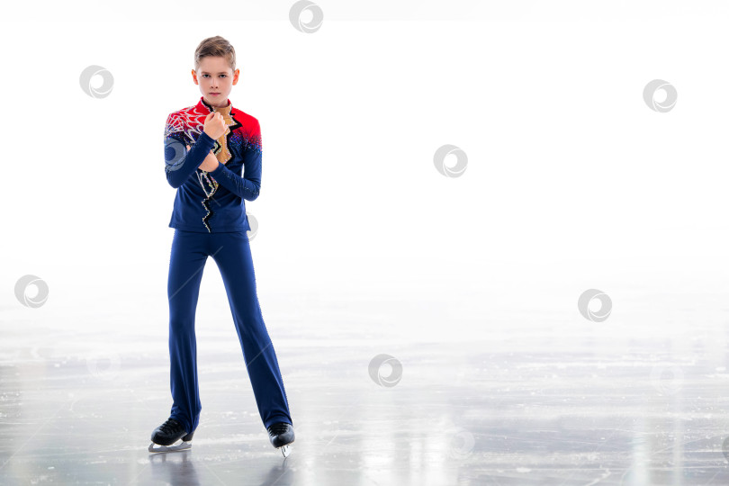 Скачать Мальчик-фигурист в шапке Санта-Клауса катается на коньках. фотосток Ozero