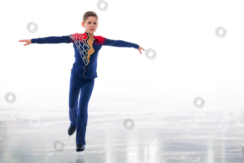 Скачать Мальчик-фигурист в шапке Санта-Клауса катается на коньках. фотосток Ozero